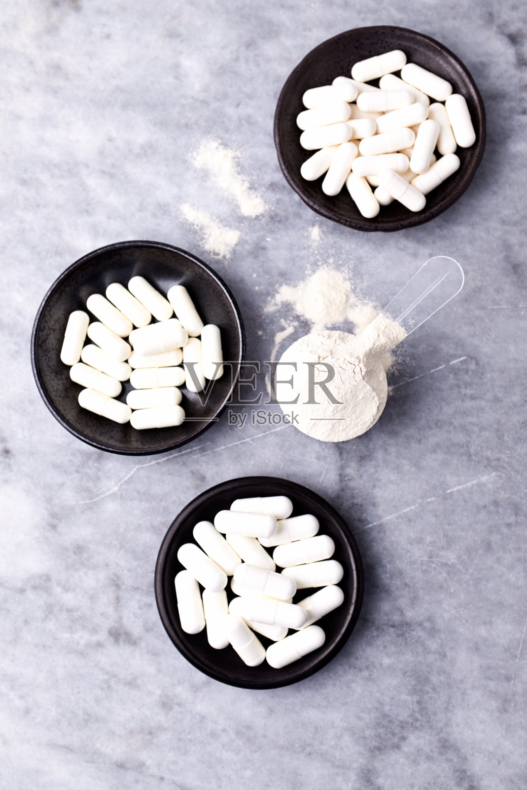 乳清蛋白,水解膠原I型,l -脯氨酸和l -賴氨酸膠囊勺。補(bǔ)充膠原蛋白的生產(chǎn)。明亮的石頭背景。直接上圖。副本的空間。